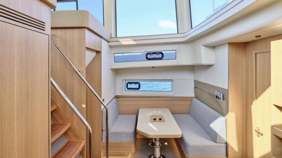 Off Lavrion the 3 cabin 6 guest Omikron Yachts OT 60 N ice featuring interior lounge with seating and dining table.