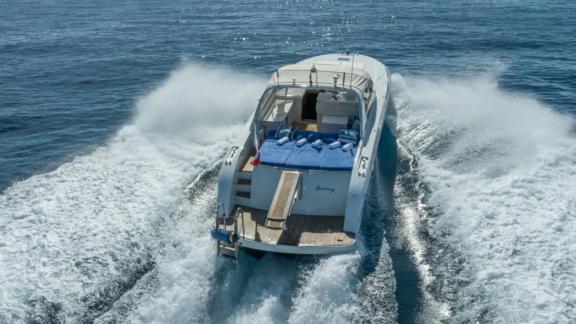 Among Cannes daily yacht rental options Omarta is seen from rear cruising fast in open sea.