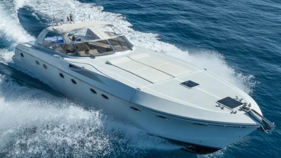 Among Cannes daily yacht rental options Omarta is seen from angled front view cruising fast in open sea.