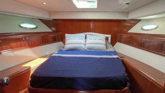 Among Cannes daily yacht rental options Omarta cabin shows double bed with simple and comfortable interior.