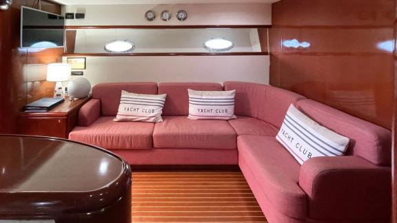 Among Cannes daily yacht rental options Omarta interior shows corner seating area with warm design.