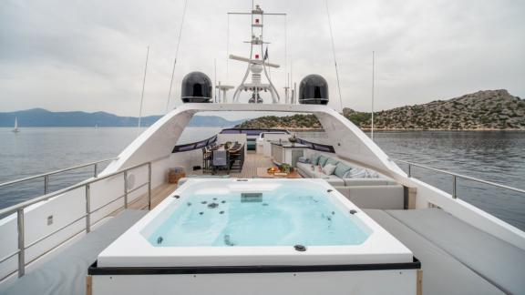 The flybridge near Athens features a jacuzzi, dining table and lounge area with panoramic views.