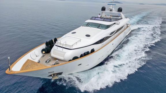 The yacht cruises near Athens with a cushioned sunbed and safety gear on the spacious foredeck.