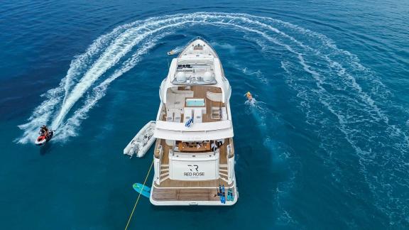 8 Gäste 4 Kabinen Motoryacht Red Rose zur Miete vor Athen in Drohnenaufnahme mit Jetski am Heck.