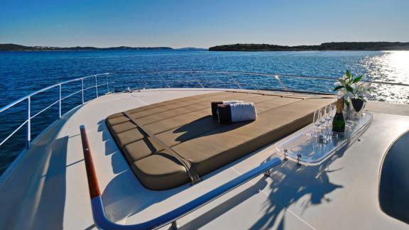 Auf dem Vorschiff der Sea U Motoryacht vor Athen befinden sich Sonnenliege und Getränke.