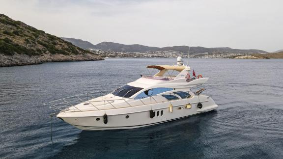 Die Motoryacht Siena liegt vor Anker in einer ruhigen Bucht mit Bergblick.