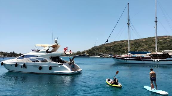 Die Motoryacht Siena liegt vor Anker, die Gäste spielen mit Wasserspielzeug.