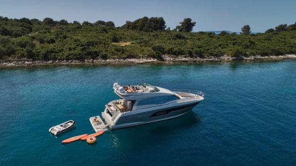 The motor yacht Simull in Croatia anchored with a coastal view, offering water toys for enjoyment.