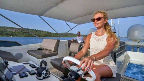 Female captain on the upper deck bridge of motor yacht Simull.