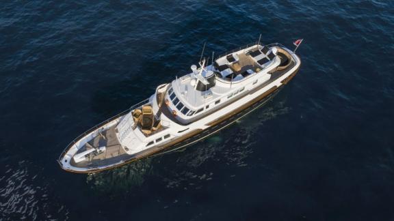 Among motor yacht rental options in Athens Sounion II is seen from above with deck and seating areas in the sea.