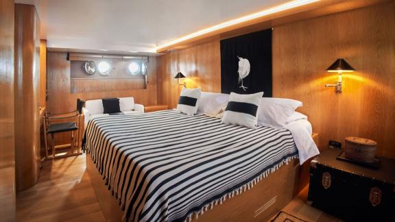 Among motor yacht rental options in Athens Sounion II master cabin with large bed and seating area is seen.