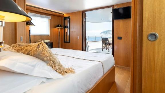 Among motor yacht rental options in Athens Sounion II cabin with bed and direct access to deck is seen.