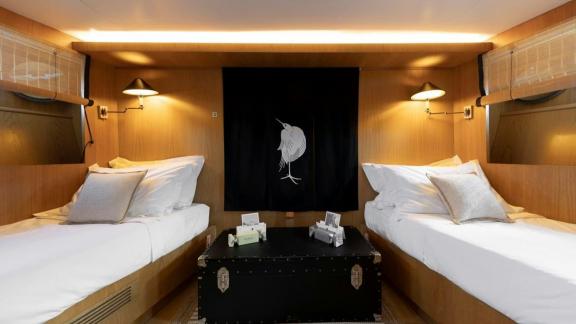 Among motor yacht rental options in Athens Sounion II twin cabin with two beds and central table is seen.