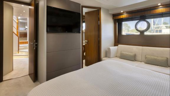 Among Nice yacht charter options Turquoise motor yacht shows cabin with bed sofa and window.