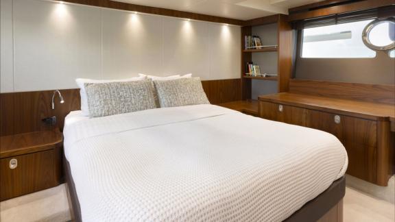 Among Nice yacht charter options Turquoise motor yacht shows cabin with large bed and modern interior design.