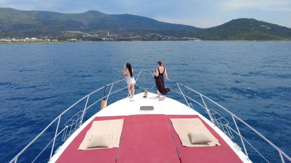 Auf dem Vorderdeck der Motoryacht Uranos genießen zwei Frauen die Aussicht.