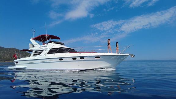 Motoryacht Uranos auf dem Meer bei Bodrum, zwei Personen sonnen sich auf dem Vorderdeck.