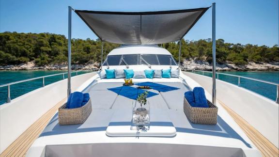 The foredeck of Wish Alfamarine 91 features large sunbeds under a canopy with a clear sea view.