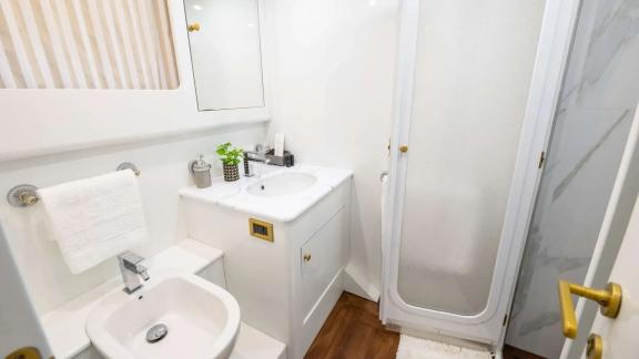 The bathroom of Wish Alfamarine 91 includes a shower cabin, sink cabinet and compact layout.