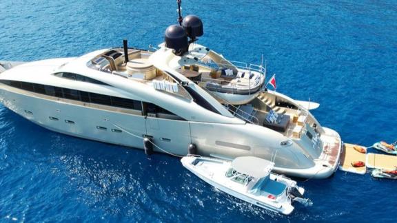 Among Mallorca yacht charter options Ycm120 shows rear platform with tender and water access.