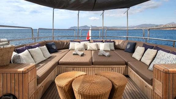 Among Mallorca yacht charter options Ycm120 shows upper deck seating and sea view.