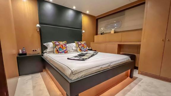Among Mallorca yacht charter options Ycm120 shows cozy cabin with bed and storage.