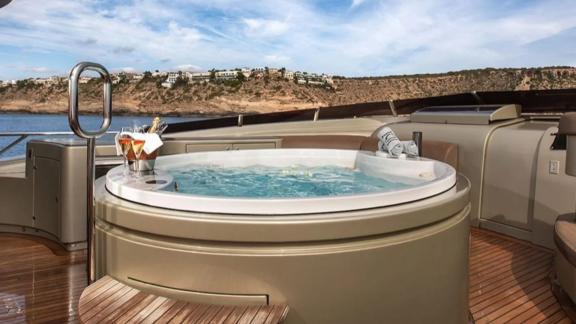 Among Mallorca yacht charter options Ycm120 shows jacuzzi and relaxation space on deck.