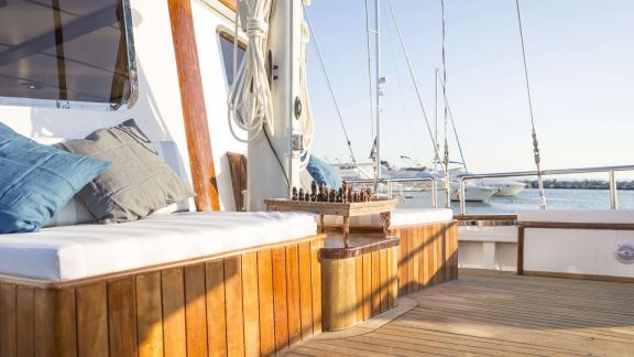 A chessboard is set up on the cushioned deck seating area of Cosmos.