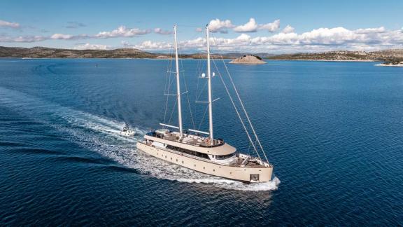 У побережья Сплита моторно парусная яхта Maxita идет по морю с широкими палубами и мачтами.