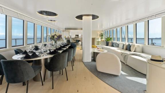 In Split motorsailer charter option Maxita interior salon with long dining table and seating area visible.