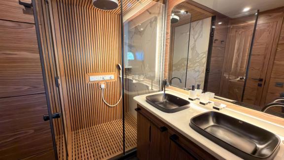 Аренда люкс гулета Oguz Marin в Бодруме предлагает стильную ванную с двойной раковиной и отделкой из дерева для комфорта