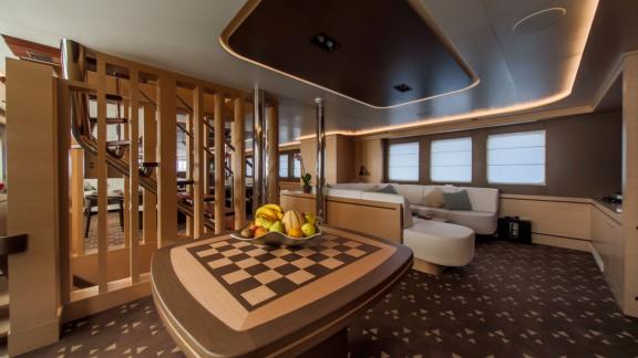 Modern lounge area on Omnia with a chess table and fruit bowl.