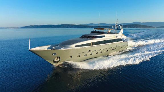 The luxury motor yacht Anavi is cruising at high speed on the open sea, showcasing an elegant and powerful design.