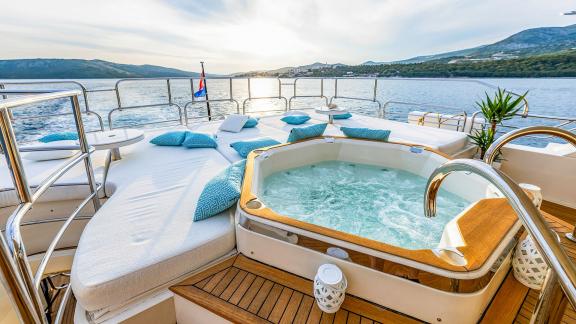 Sunseeker 34m Arago motoryatın kıç güvertesinde jakuzili ve minderli güneşlenme alanı.