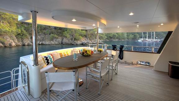 Archsea motoryatın arka güvertesinde meyve servisi eşliğinde doğa manzaralı keyifli bir ortam sunuluyor.