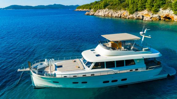The Cloud 9, a Menorquin 68 FB yacht, sails gracefully along Dubrovnik’s calm coast offering timeless elegance.