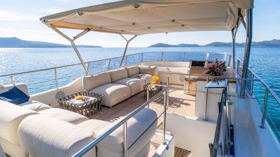 The Menorquin 68 FB motor yacht Cloud 9 features a shaded flybridge lounge area with panoramic sea views and deluxe comf