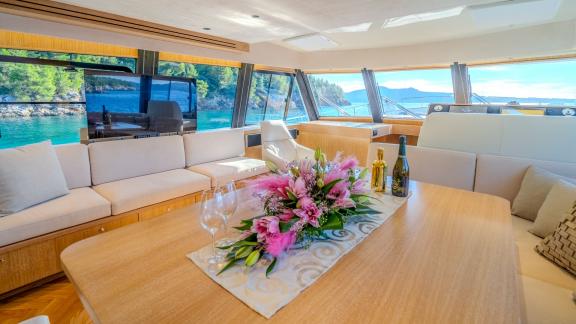 The spacious salon at the front of the yacht features panoramic windows that bring the sea view indoors.