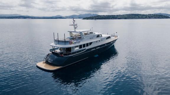 Die Yacht Dream liegt bei bewölktem Himmel ruhig vor Anker. Ideal zum Chartern.