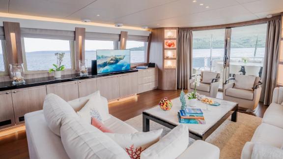 Heller Innenraum mit Fernseher, Sofas und Aussicht bietet besten Komfort zum Chartern.