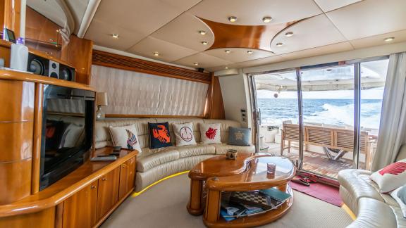 The luxurious salon of the Edition yacht features a comfortable seating area and large glass doors with a sea view.