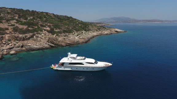 The Efmaria motor yacht anchored near a rocky coastline in Greece.