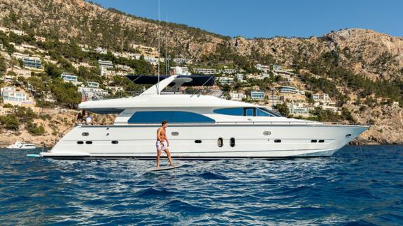 Ehthele yacht anchored in Mallorca as a guest enjoys a water toy nearby.