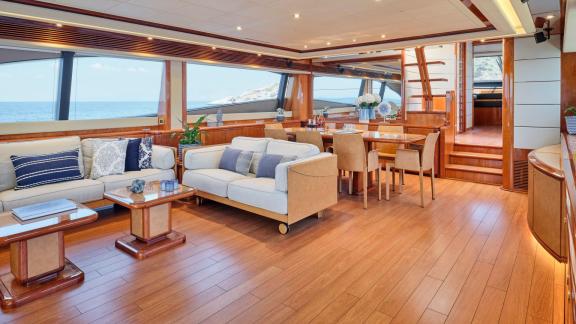 Luxurious dining and seating area inside a yacht with sea view through large windows