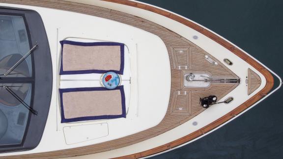 On the front deck of the yacht Estia Zeus, two beach towels and an anchor, seen from above.