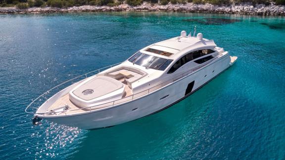 The white luxury yacht For Ever glides gracefully over crystal-clear turquoise waters.