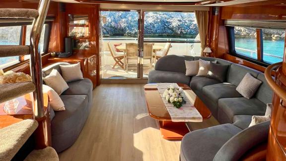 Freya motoryatının şık salonu, geniş camlar ve konforlu oturma alanıyla dış güverteye açılan huzurlu bir yaşam alanı sun