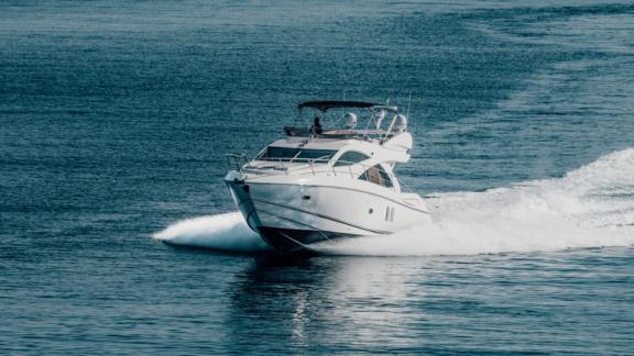 The motor yacht Funseeker speeds across the blue sea, turning heads with its elegant design.