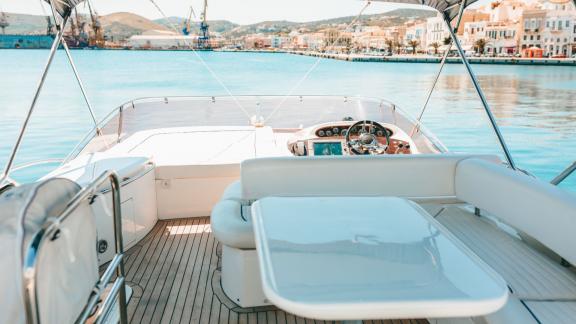 Auf dem Flybridge der Yacht Funseeker befinden sich eine weiße Sitzecke und ein Steuerstand mit Blick auf den Hafen.