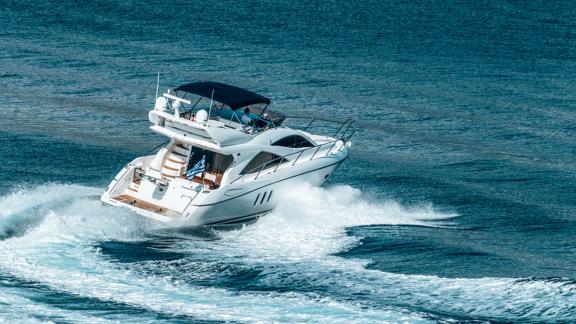 The motor yacht Funseeker navigates the open sea with smooth turns, leaving white foam in its wake.